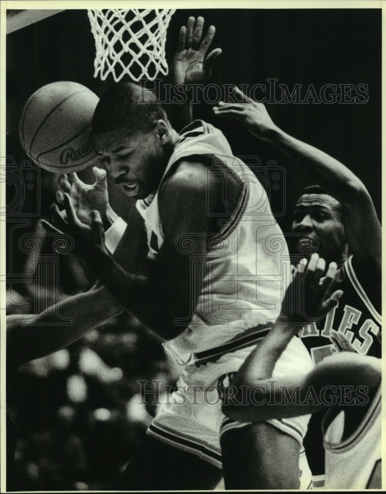 1988 Press Photo Bruce Wheatley bobbles ball against Alvaro Teheran, Basketball- Historic Images