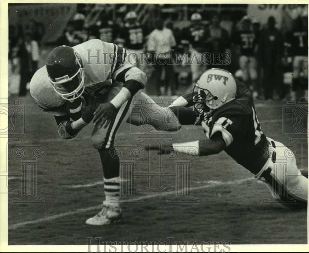 1986 Press Photo Southwest Texas College Football Player Tackles Billy Brewer- Historic Images