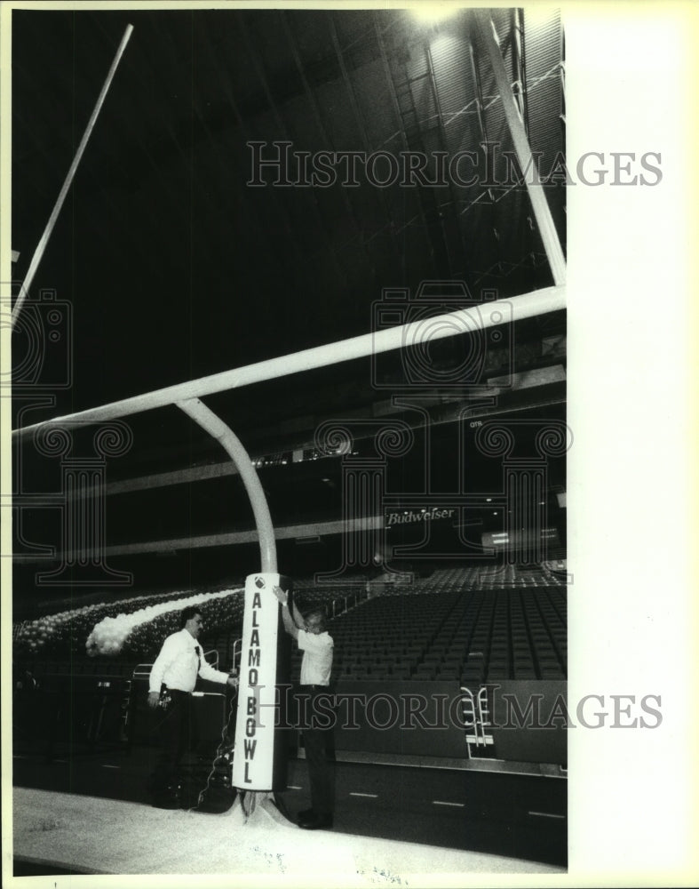1993 Press Photo Officials Attach Alamo Bowl Signs at Alamodome Goal Post- Historic Images