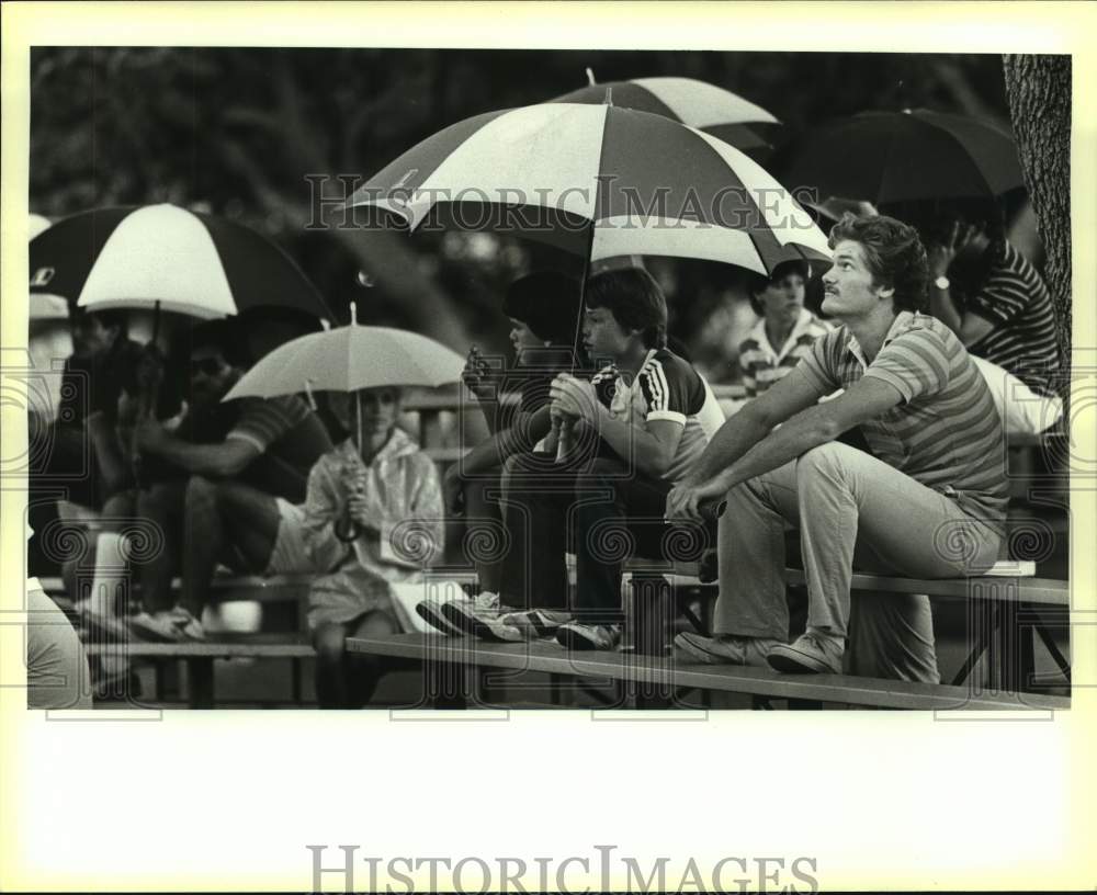 1984 Press Photo Golf fan Charles Bippert waits out the rain at the Texas Open- Historic Images