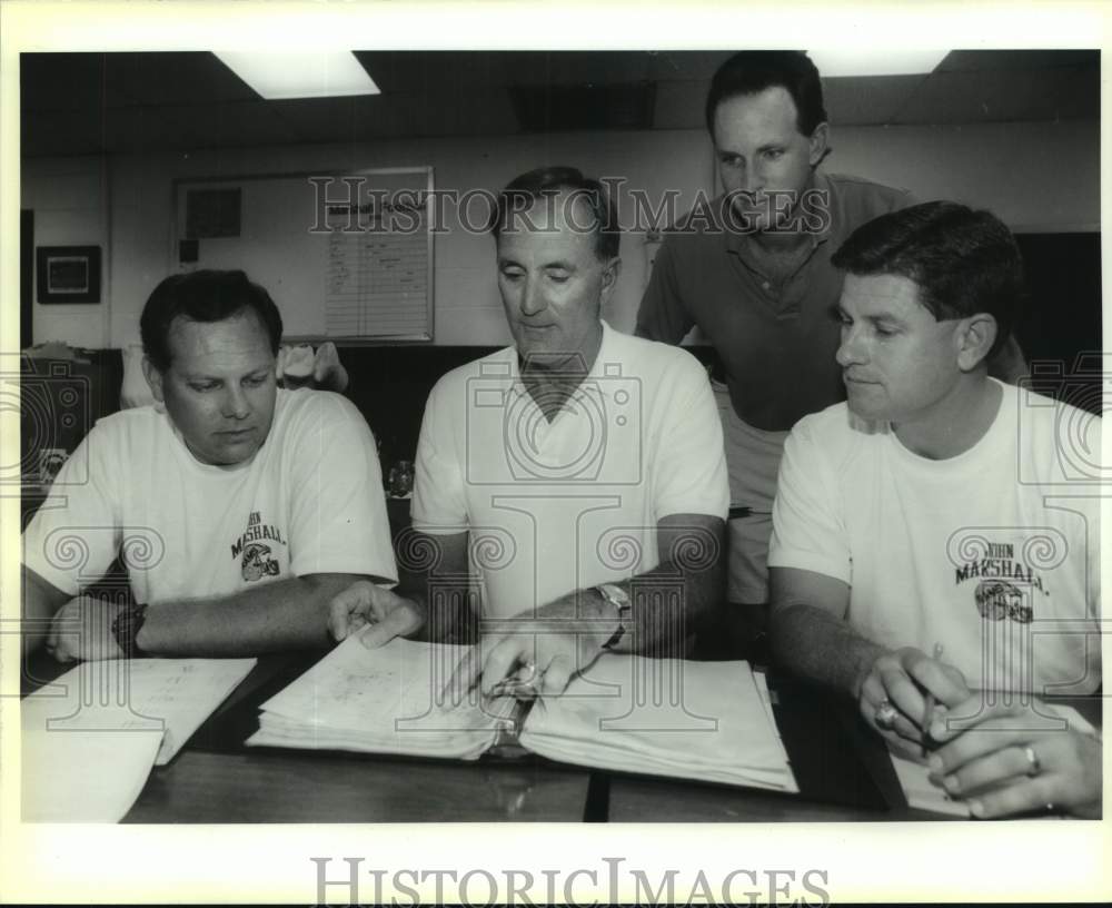 1991 Press Photo Marshall High Football Coaches Look at Binder During Meeting- Historic Images