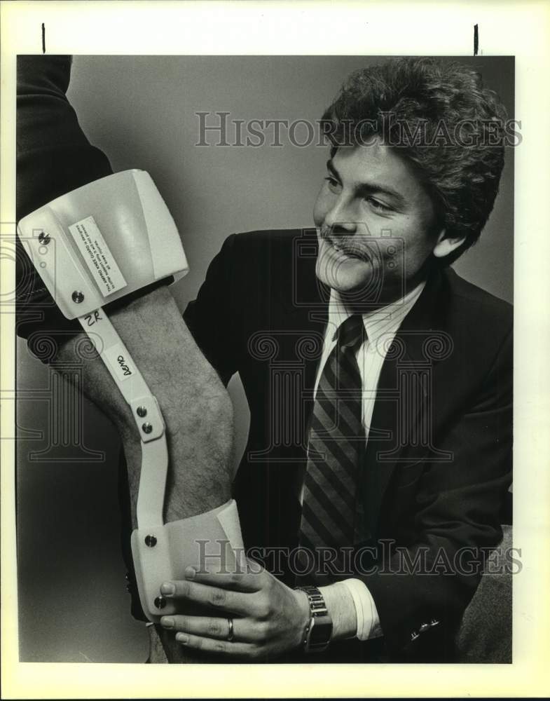 1986 Press Photo Athletic Trainer Jeff Worrell Fits Man With Leg Brace- Historic Images