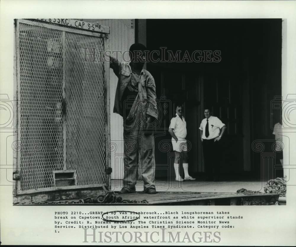 Press Photo Black longshoreman takes break on Capetown, South Africa, waterfront