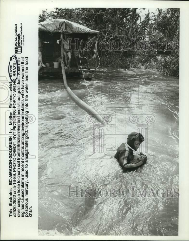 1989 Press Photo A diver using a hose to churn soil from a Brazilian riverbed- Historic Images