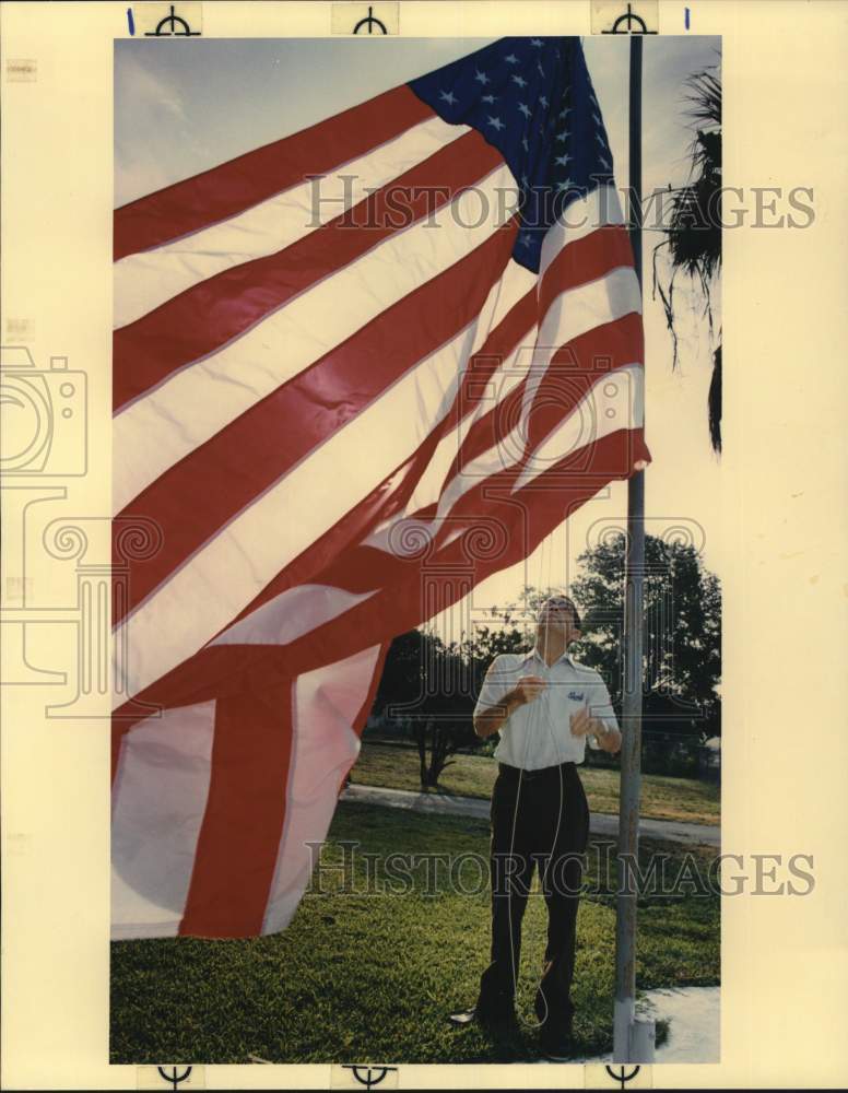 1990 Press Photo F.L. Button prepares to raise his flag at home on Formosa Place