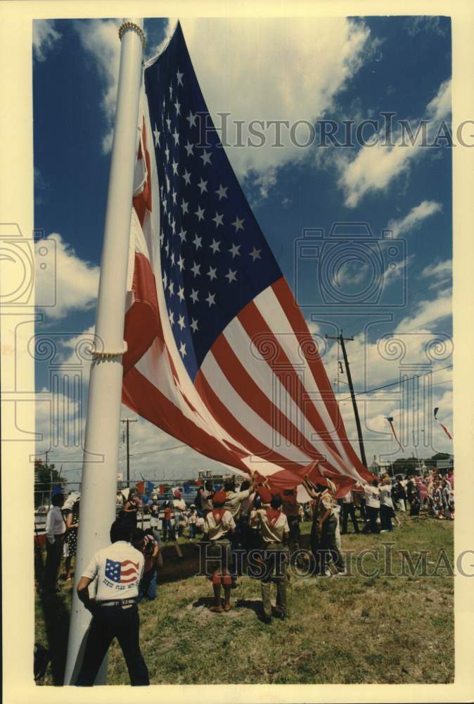 1990 Press Photo Boy Scout remove huge 30 x 60 flag from flag pole at Dixie Flag- Historic Images