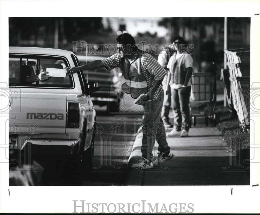 1993 Press Photo John Ybarra snags a tax return from a motorist on Perrin Beitel- Historic Images