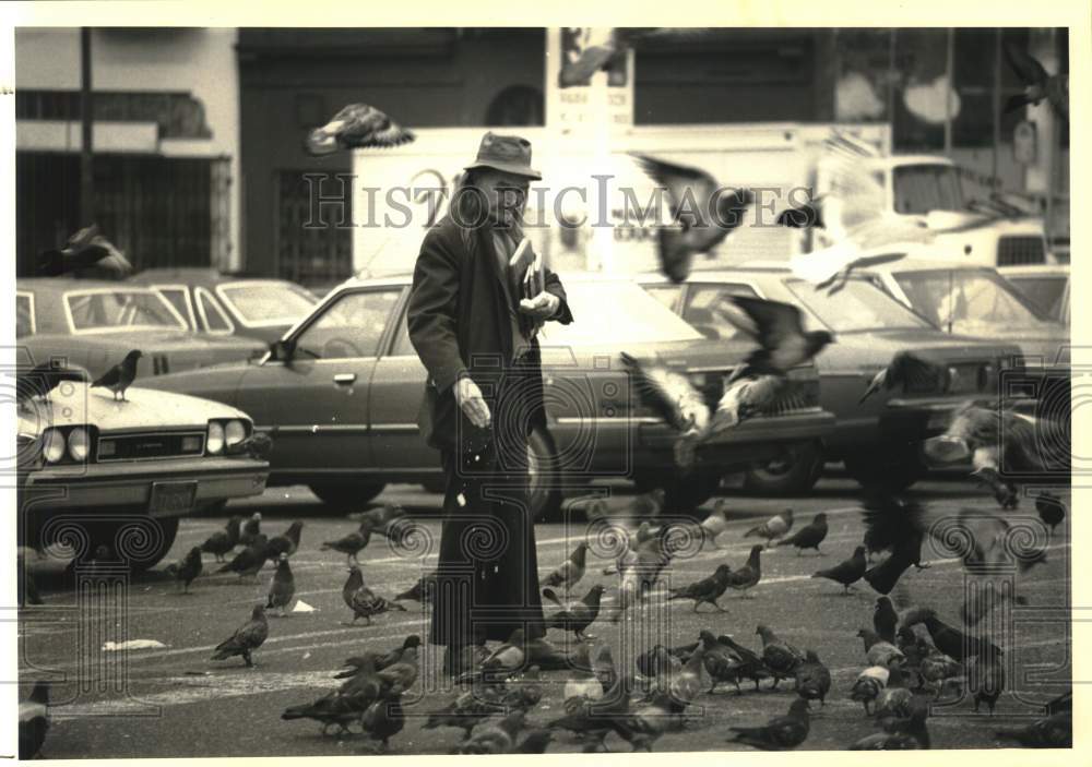 1987 Press Photo A man feeds the birds in San Francisco's Tenderloin district- Historic Images