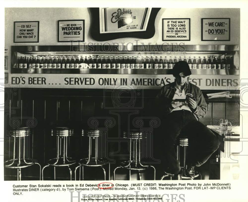 1986 Press Photo Stan Sokalski reads a book in Ed Debevic's diner in Chicago- Historic Images