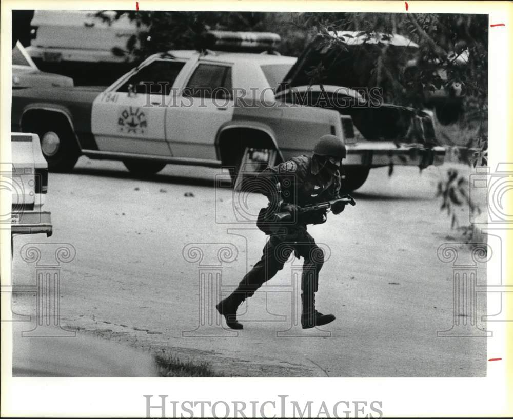 1985 Press Photo SWAT member runs across street during 7123 Hobson siege- Historic Images