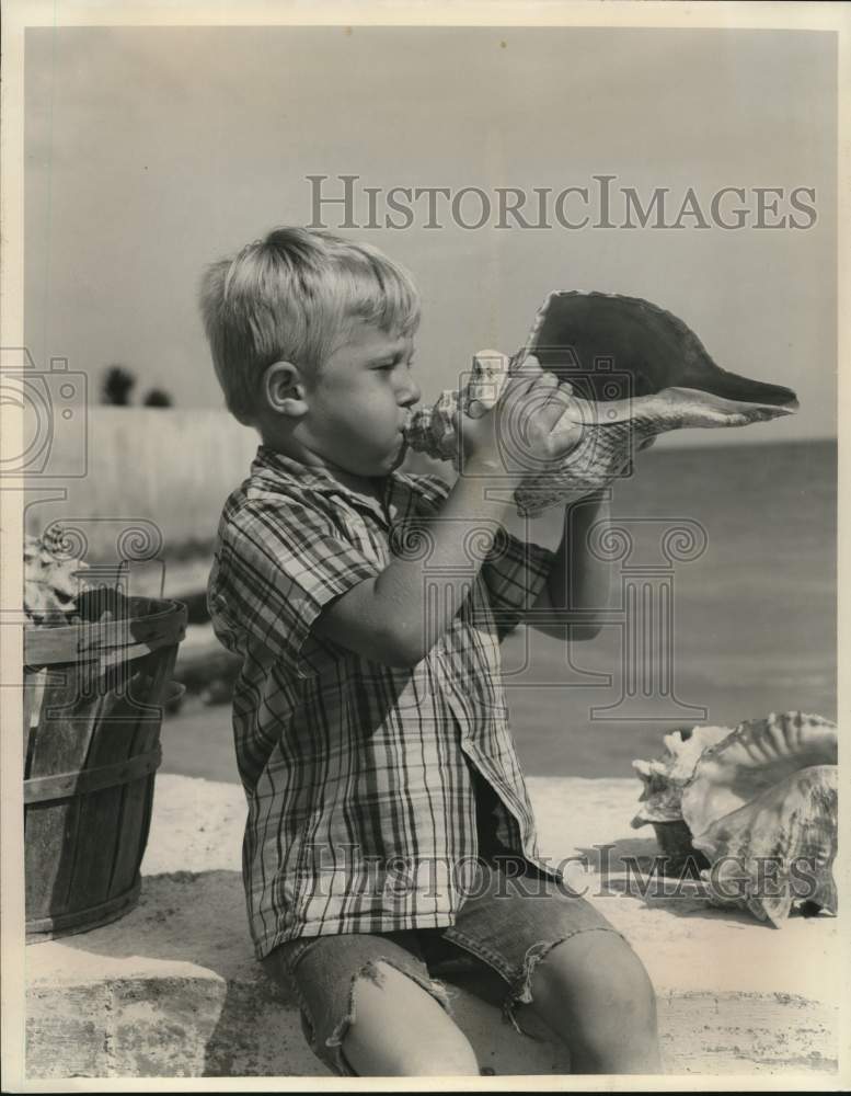 1974 Press Photo Boy Blowing Conch Shell at Florida Beach - sax26091- Historic Images