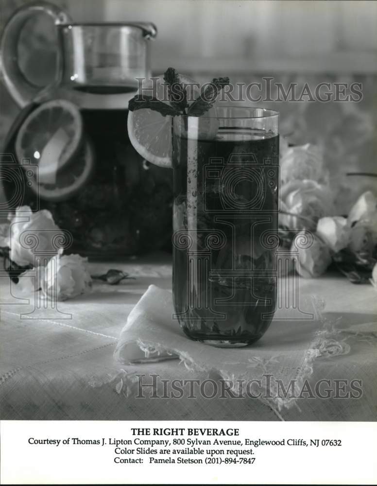 Press Photo Glass of Iced Tea with Mint Garnish and Serving Pitcher with Roses- Historic Images