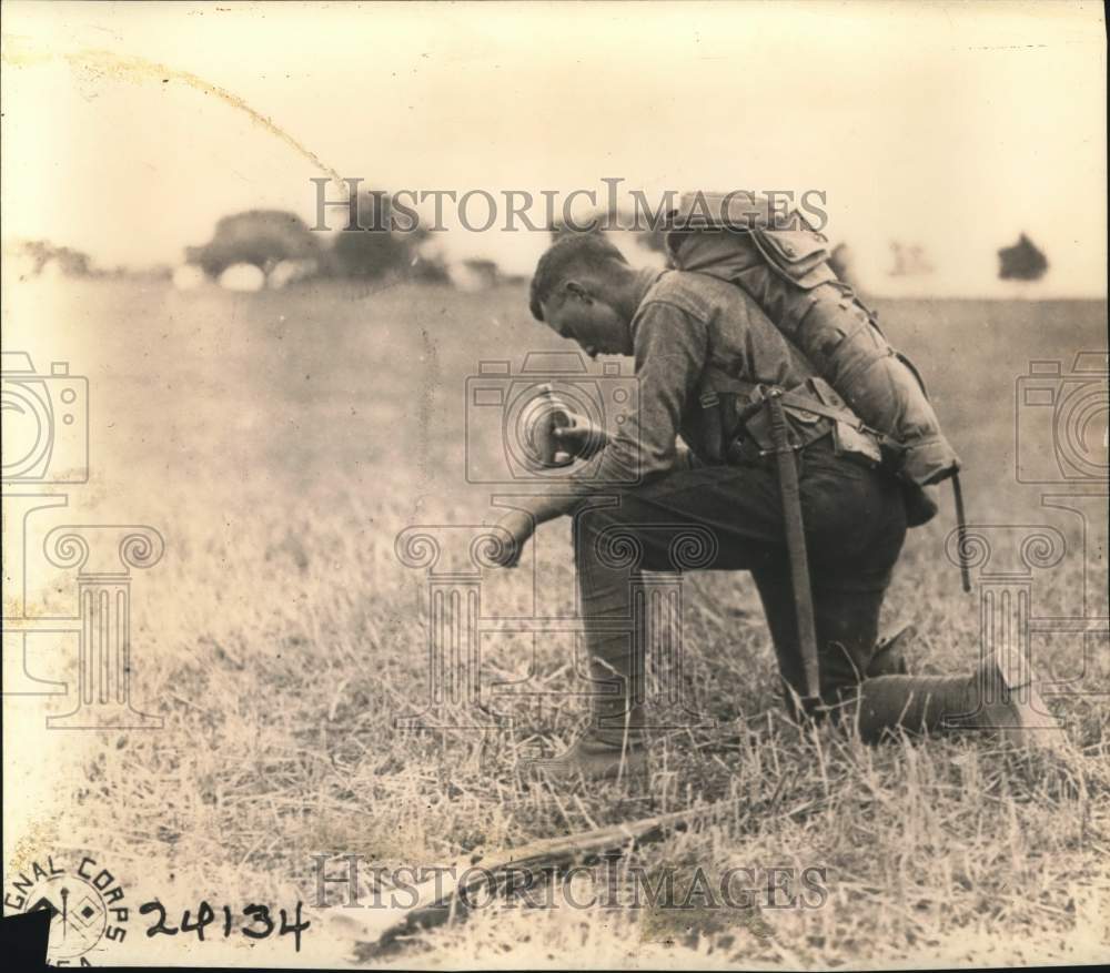 Press Photo A soldier rests, takes a drink during military training - sax27823