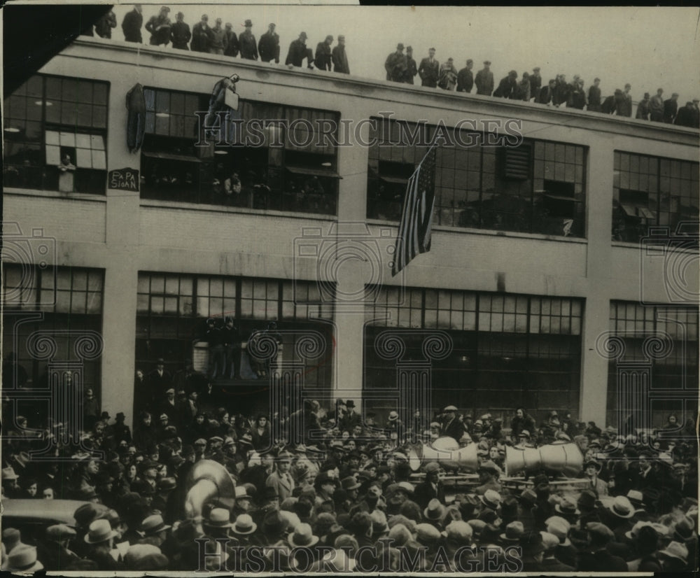 Press Photo Striking motor workers at GM plant as execs look down from roof