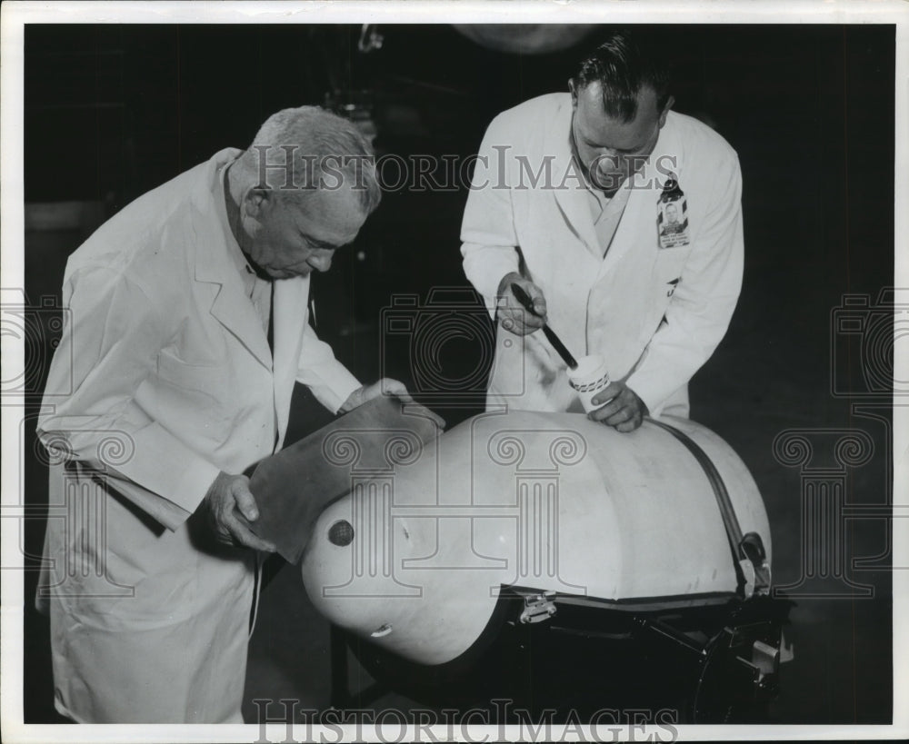 Press Photo Workers working on a engine - sba16627