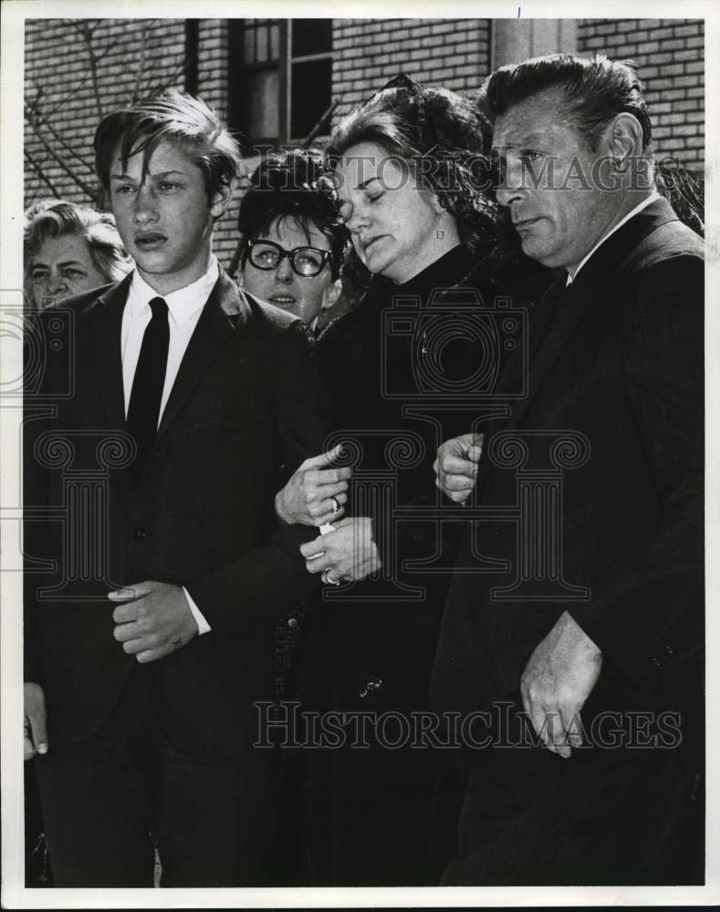 1967 Press Photo Group embraces as they walk away from a building - sia25788- Historic Images