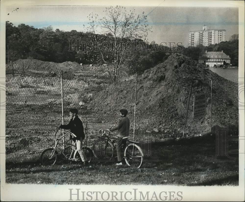 1967 Press Photo Two cyclists view Clove Lakes Park War Memorial Ice Rink site- Historic Images