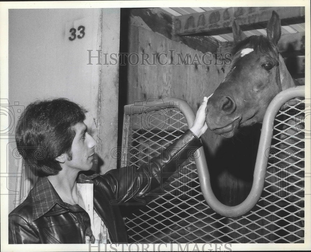 1980 Press Photo Jockey Richard Ochoa petting a horse in its stall - sps10343- Historic Images