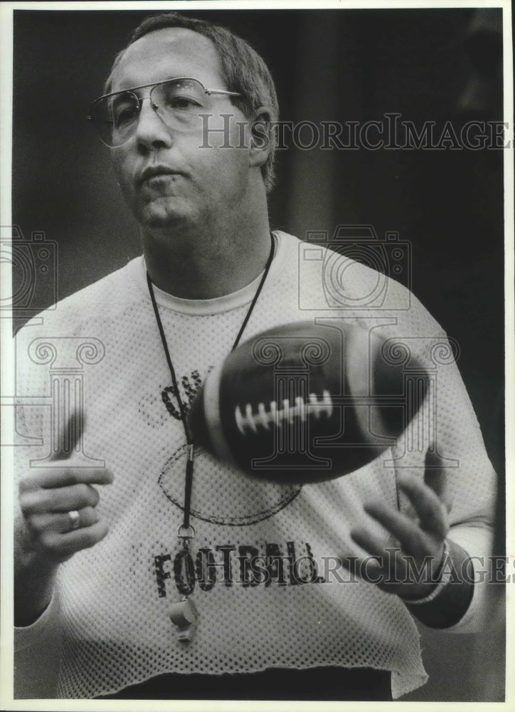 1988 Press Photo Tom Oswald tosses up a football while watching his team- Historic Images