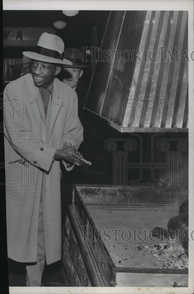 1954 Press Photo Boxer Sandy Saddler warms himself by a fire - sps14351- Historic Images