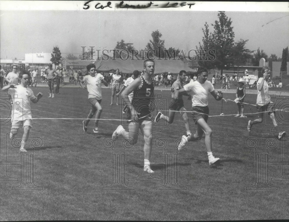 1971 Press Photo Special Olympics runners hit the finish tape of a race- Historic Images