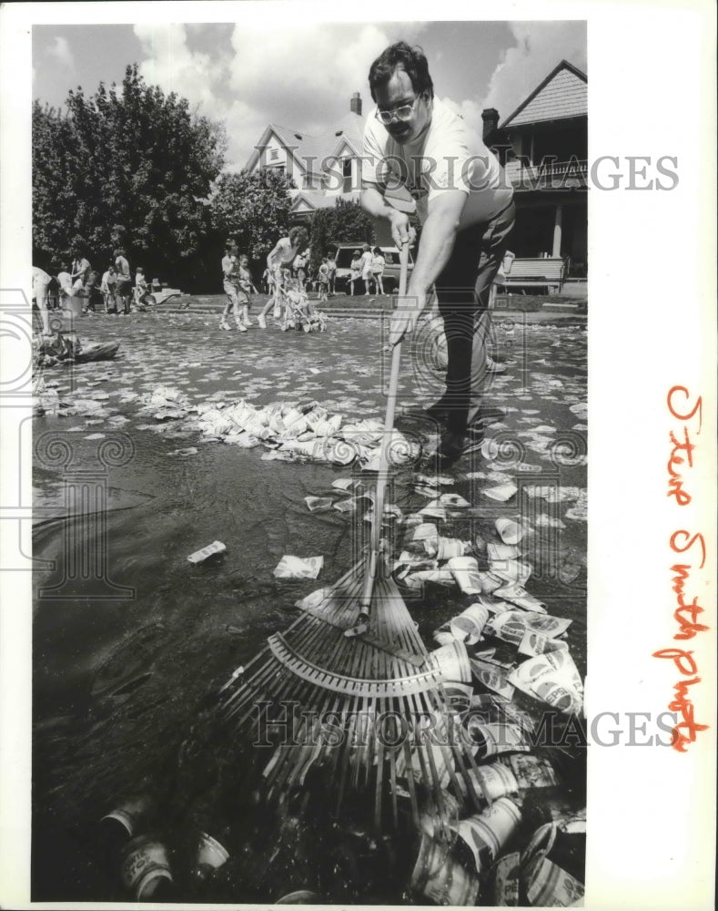 1989 Press Photo Volunteer, Tex Reifle, cleans up final Bloomsday water station- Historic Images