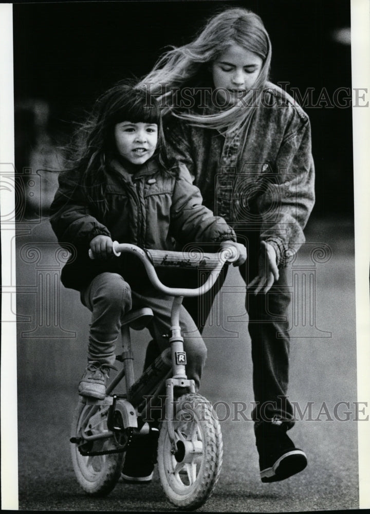 1989 Press Photo Angie helps sister Tristan Umland Learn to Ride a Bike- Historic Images