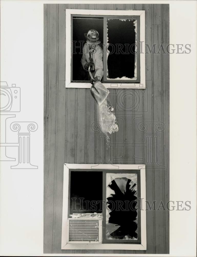 1988 Press Photo Richard Cheeks shovels debris out window after fire, MA- Historic Images