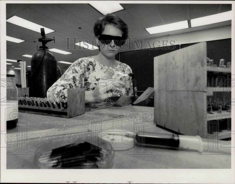 1990 Press Photo Laura Sheppard holds glass vials for kaleidoscope colored oils.- Historic Images