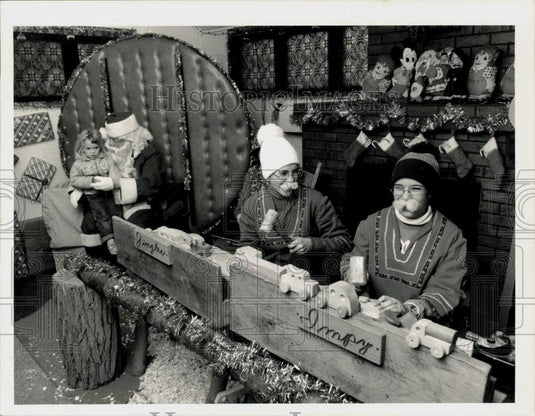 1988 Press Photo Laura Kaniecki Sits on Santa's Lap, Elves Work, Northampton, MA- Historic Images