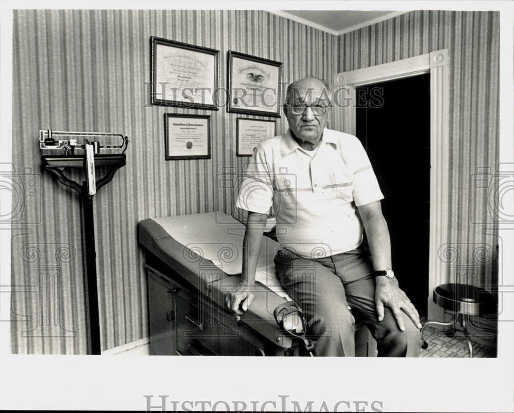 Press Photo Dr. Edward Dill sits in his Ludlow examining room. - sra22432- Historic Images