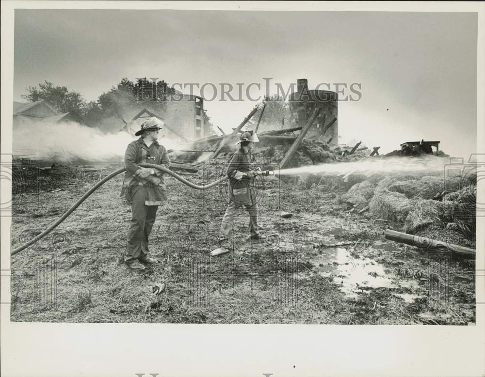 1984 Press Photo Firemen Lawrence Woznicki/Richard Turgeon Pour Water on Hay, MA- Historic Images