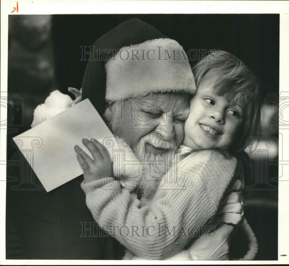 1990 Press Photo Breann Moore Hugs Santa Claus at Santa&#39;s Workshop in New York- Historic Images