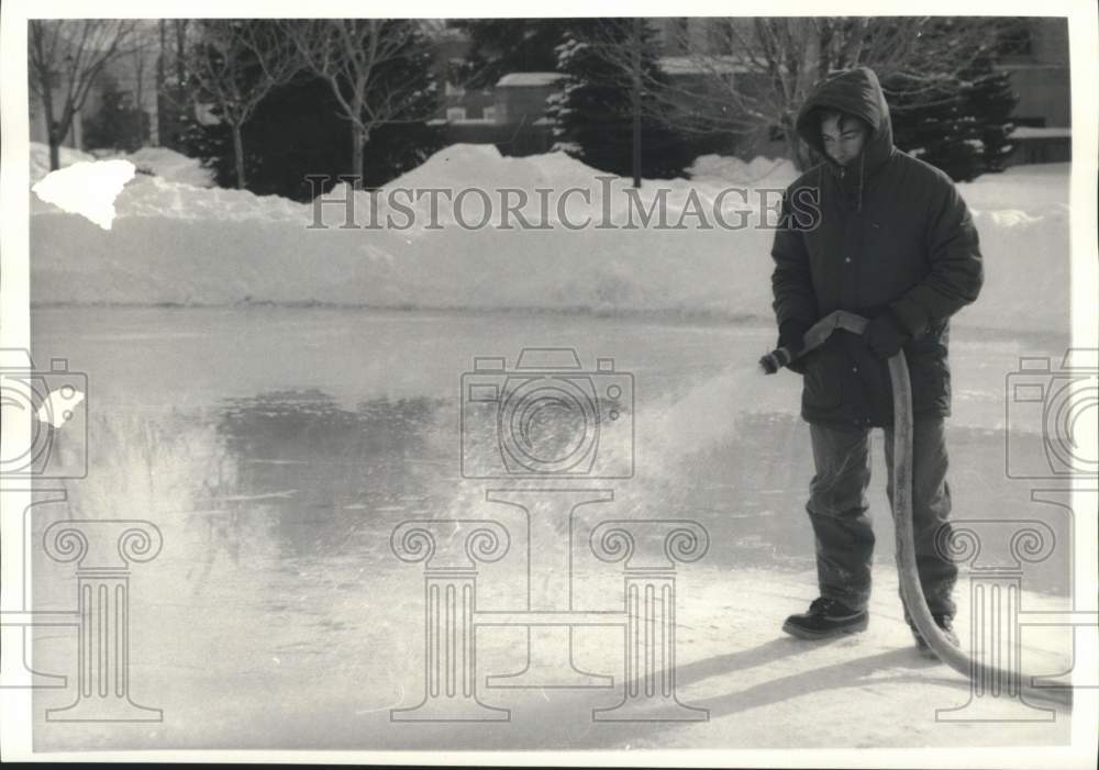 1986 Press Photo Gino Sonnacchio Hoses Ice Skating Ring at Courthouse Park- Historic Images