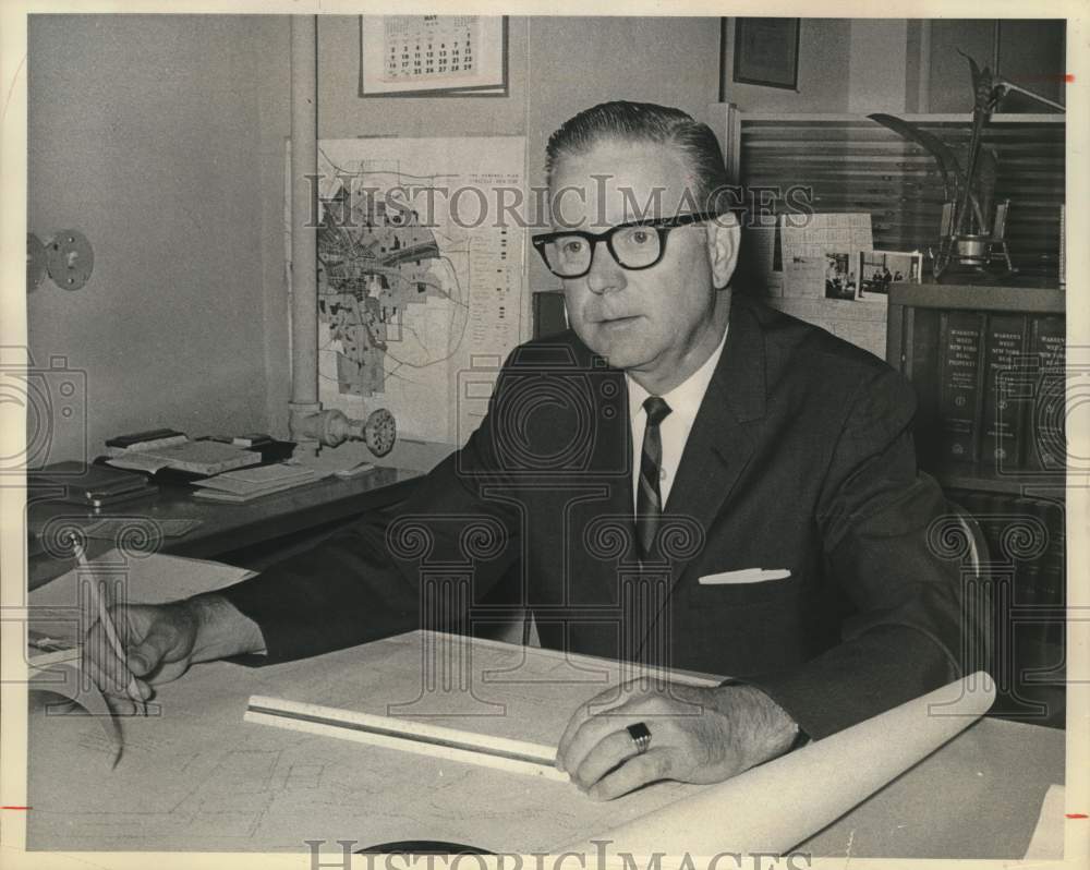 Press Photo Man in Office with Blueprints and Maps - sya14136