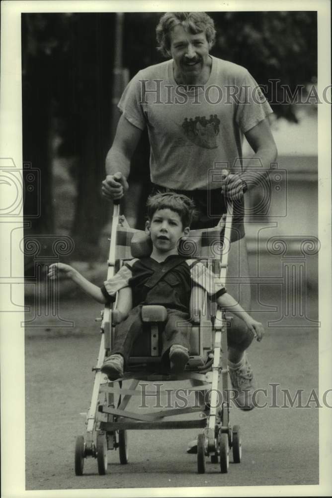 1984 Press Photo Doctor Rene Willett Pushing Son Mark in Stroller - sya19166- Historic Images