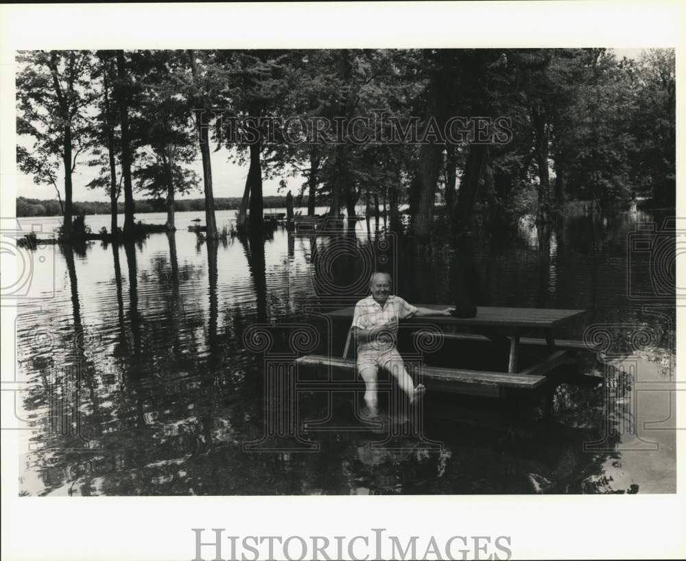 1992 Press Photo Mike Tworek sits at Picnic Table, flooded Cross Lake, New York- Historic Images