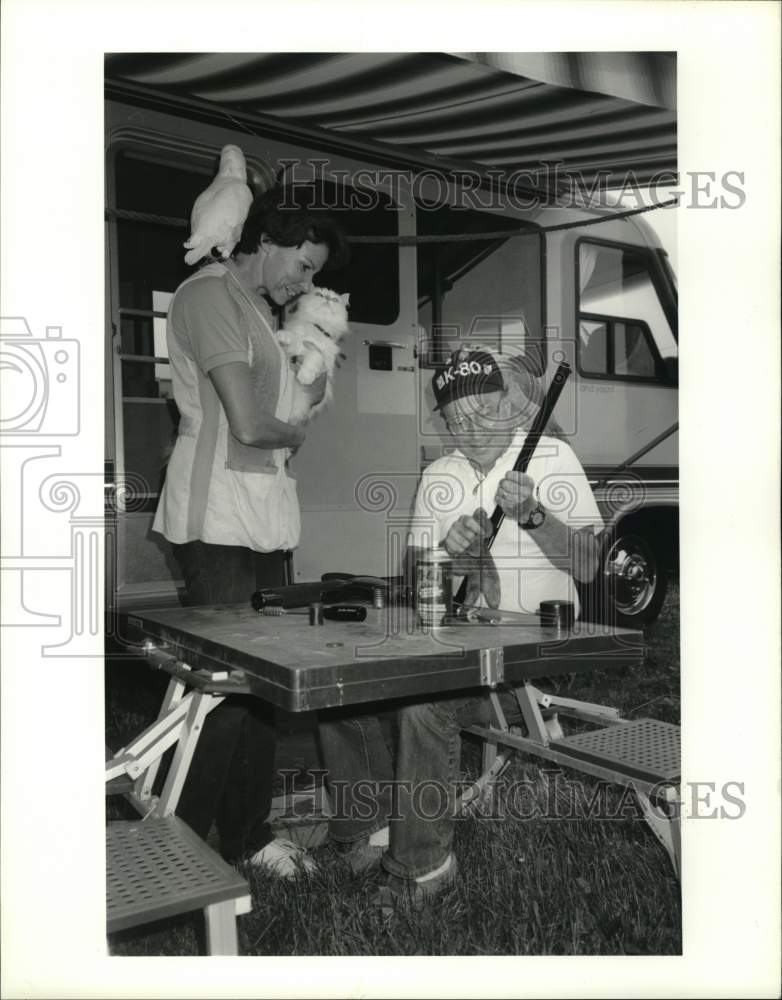 1990 Press Photo Dr. Hugo Keim Cleaning Weapon at Recreational Vehicle with Wife- Historic Images