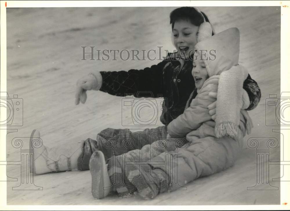 1991 Press Photo Ashley Colvin and Rhianna Roch Sledding down Pearson's Hill- Historic Images