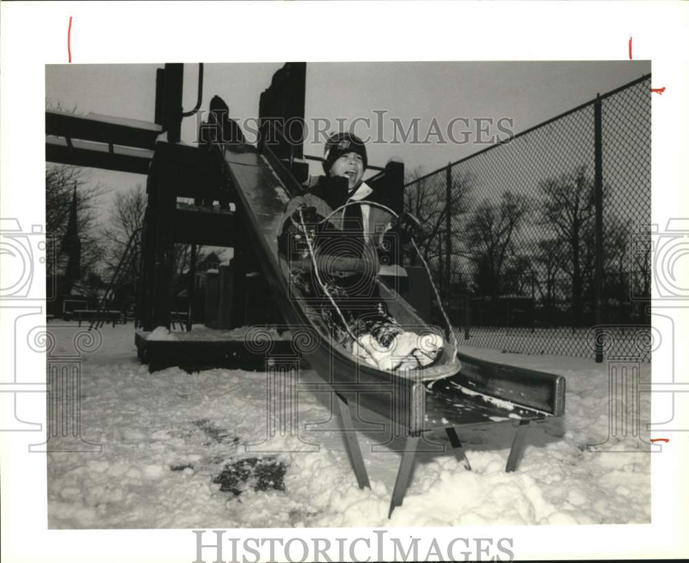 1991 Press Photo Antonio Rivera slides in Sled at West End Park, Syracuse- Historic Images