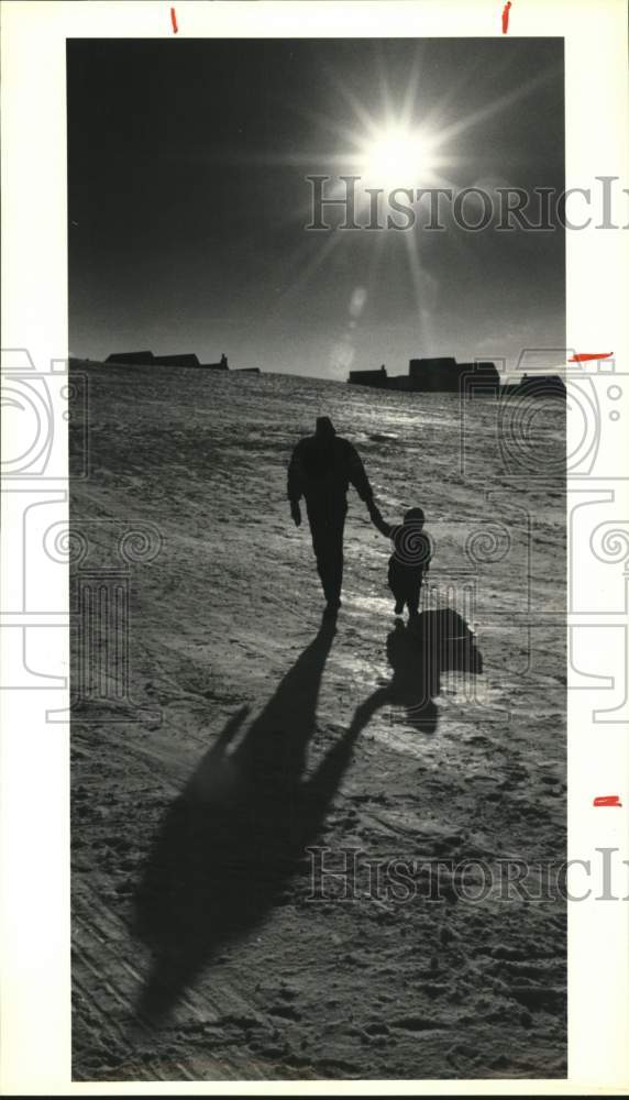 1989 Press Photo Syracuse-Paul Hopkins and son Ryan climb a hill with their sled- Historic Images