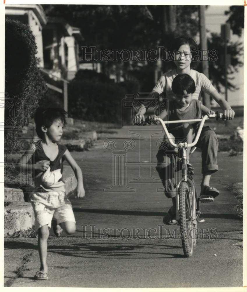 1990 Press Photo Hieu Nguyen Riding Bicycle with Brothers in Syracuse, New York