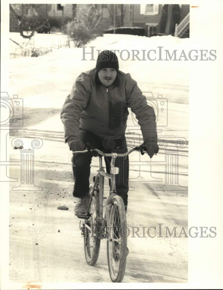 Press Photo Man rides Bicycle in Snow - sya66345- Historic Images