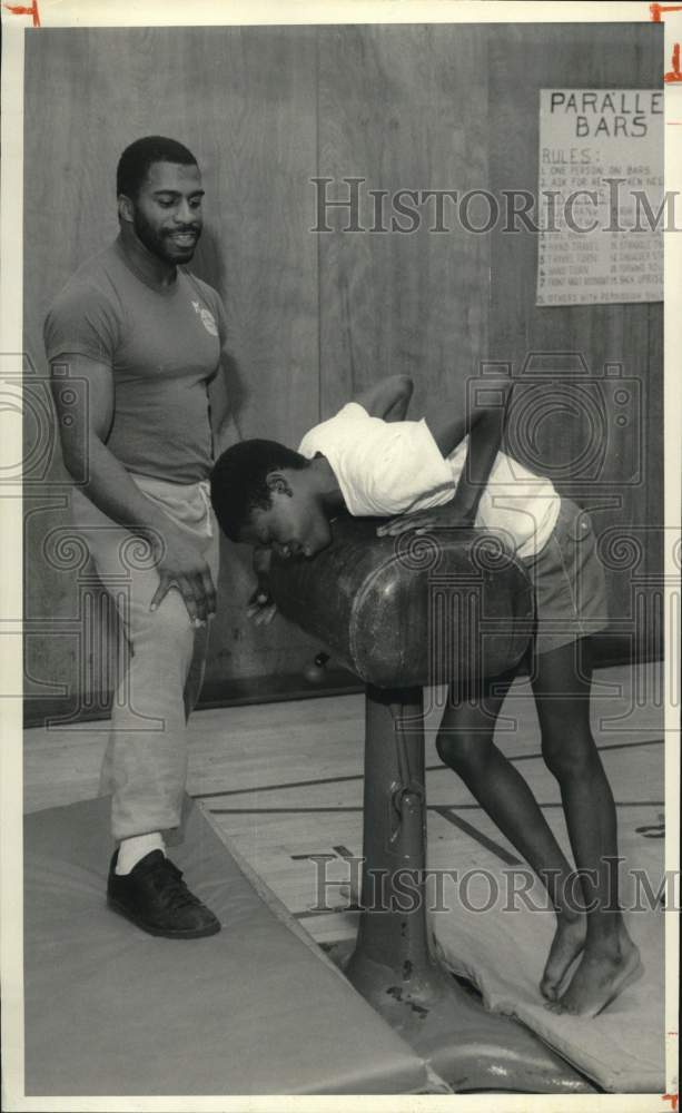 1986 Press Photo Rodger Fields grimaces at Gymnastics Training with Spotter- Historic Images