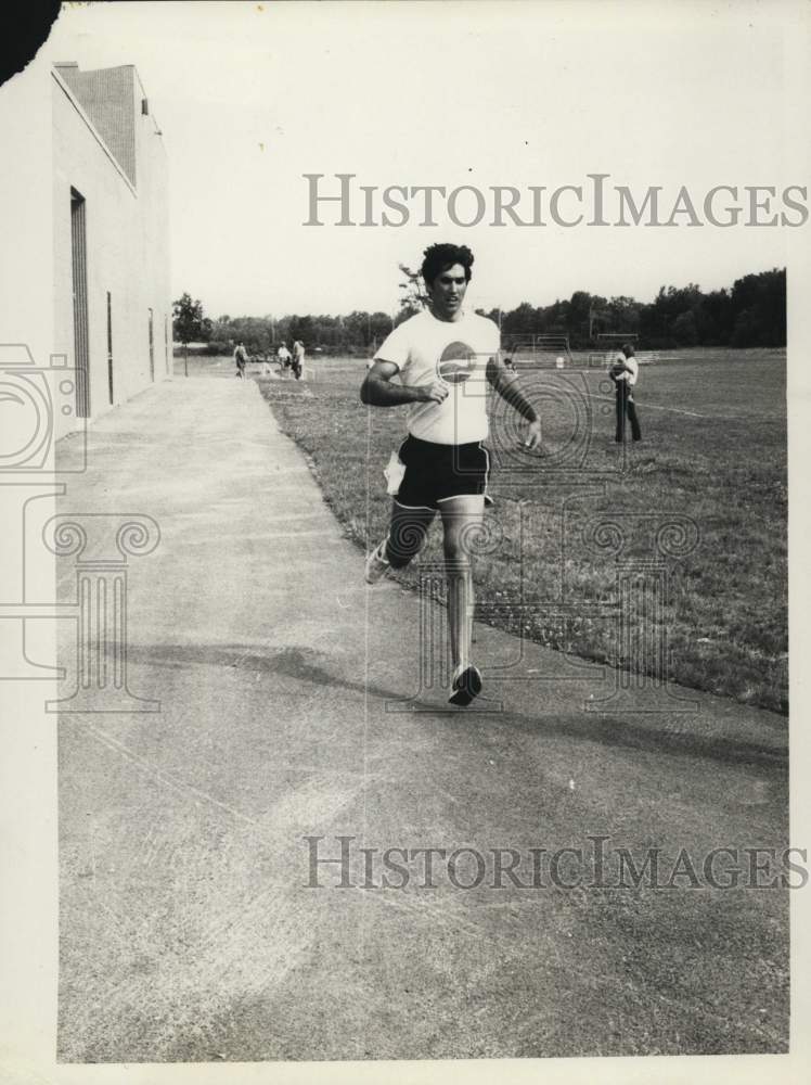 Press Photo Runner Passing Field at Event - sya79009- Historic Images