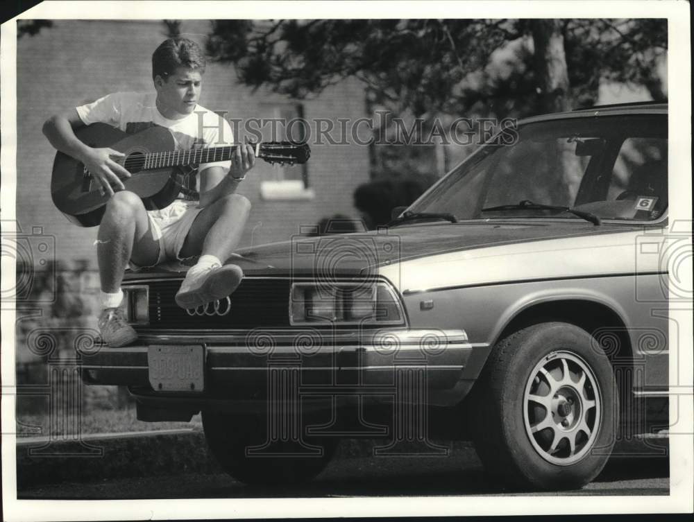 1987 Press Photo Syracuse University Student Jason Robbins Plying Guitar on Car- Historic Images