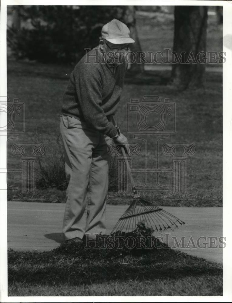 1987 Press Photo John J. Honors rakes Leaves in yard of 303 Fremont Road- Historic Images