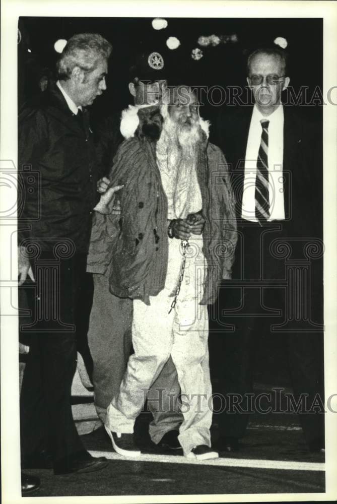 1985 Press Photo Bhagwan Shree Rajneesh is escorted to a plane in Seattle- Historic Images