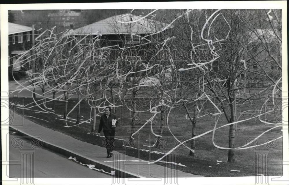 1989 Press Photo Warren Bevard with toilet papered Trees at LeMoyne College