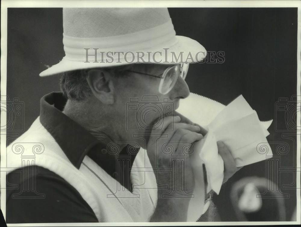 1987 Press Photo Steve Ardia eating hotdog at MONY golf tournament, New York- Historic Images